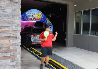 Employee guiding into car wash tunnel